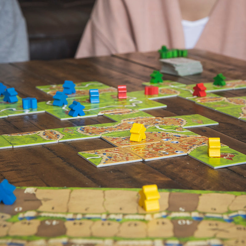 Load image into Gallery viewer, Carcassonne Board Game lifestyle image of game displayed on table including game tiles and meeples.