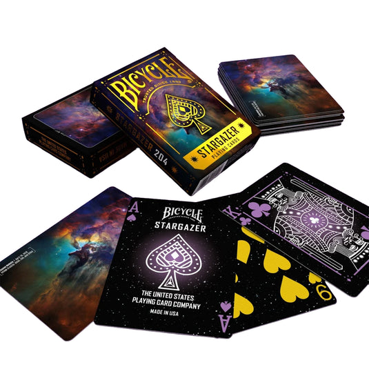 Bicycle Stargazer 204 Playing Cards - view of box and sample cards. Backs of cards feature Lagoon Nebula imagery from Hubble Telescope. Front of cards has space themed art design.