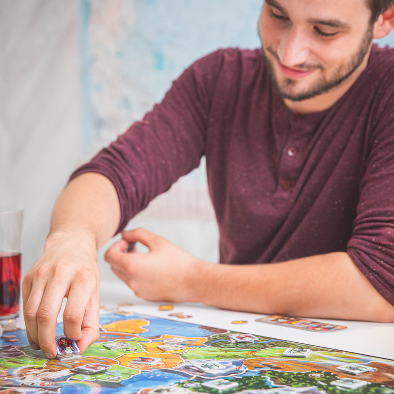 Load image into Gallery viewer, Small World Board Game - Lifestyle image of people playing Small World game.
