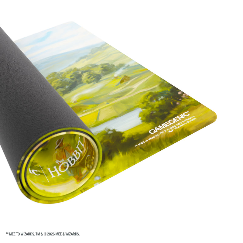 Load image into Gallery viewer, Magic: The Gathering | The Hobbit Prime Playmat - The Shire - View of partially rolled up playmat with Gamegenic branding in the corner. 
