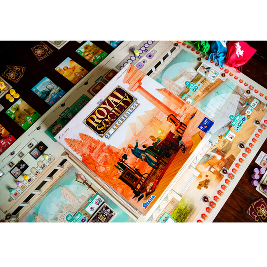 The Royal Society of Archeology - View of front of game box on top of game board.