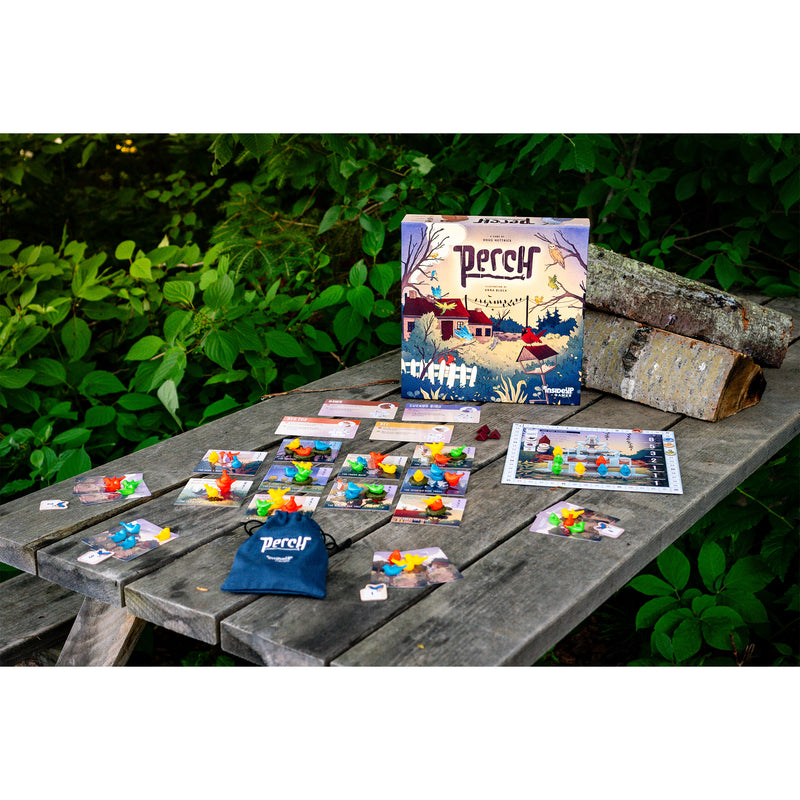 Load image into Gallery viewer, Perch Board Game - box and sample components shown on top of picnic table including cards, game board, draw bag, and bird figures.
