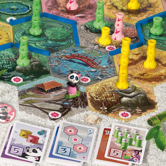 Takenoko Chibis Eco - Game components shown including panda miniature, game cards, map tiles, and bamboo figures. 