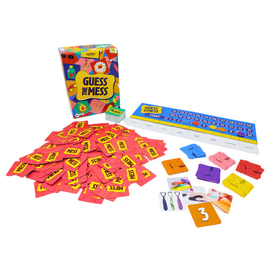 Guess The Mess Party Game - box and game components displayed including pile of mess cards, game board with score track, and place cards. 
