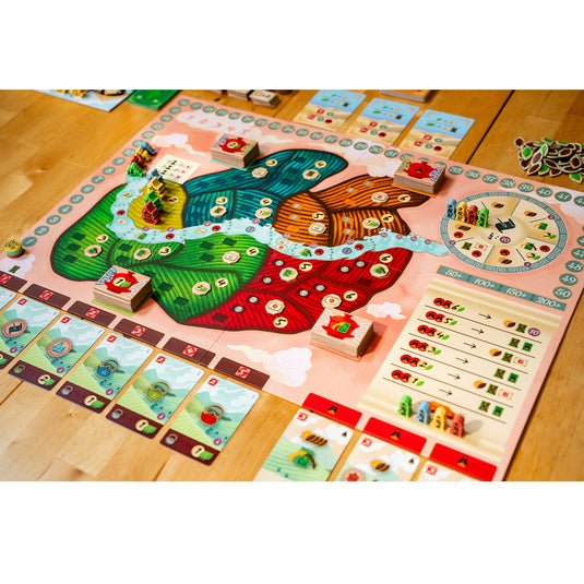 Tea Garden Board Game - sample components shown including game board with fields in different colors, building meeples in different colors, tea leaf tokens, and game cards.