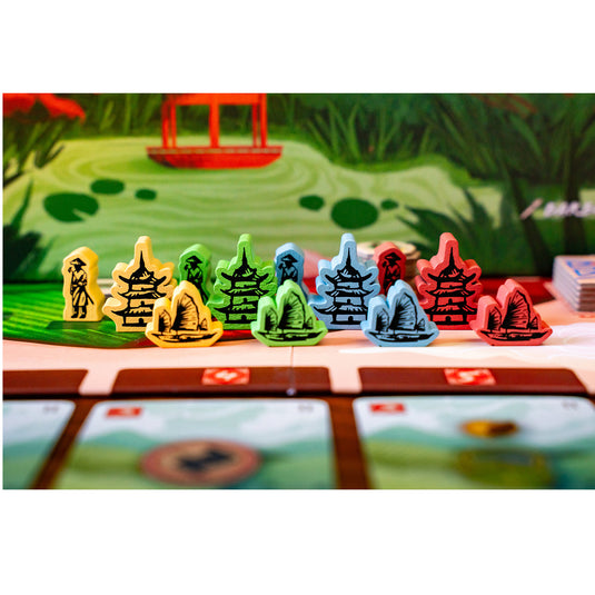 Tea Garden Board Game - boat, building, and farmer meeples shown in four different colors. 